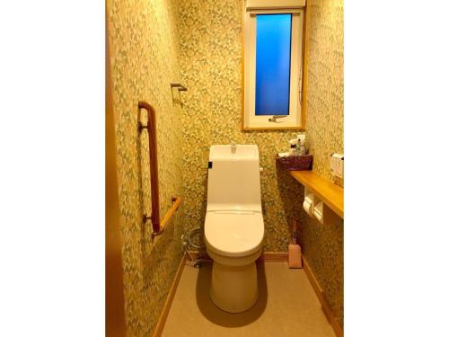 La salle de bains est pourvue de toilettes blanches et d'une fenêtre. dans l'établissement Farm Inn Torch A - Vacation STAY 92716v, à Tsurui