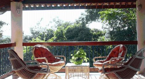 three chairs and a table on a porch at Portal Lençóis in Lençóis
