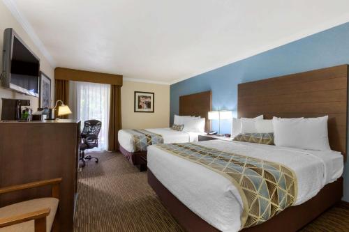 Best Western Airport Albuquerque InnSuites Hotel & Suites في ألباكيركي: غرفه فندقيه سريرين وتلفزيون