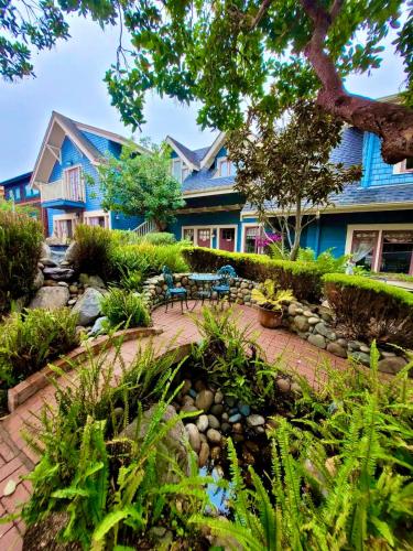 a blue house with a garden in front of it at The Old St Angela Inn in Pacific Grove