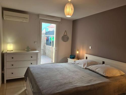 une chambre avec un lit, une commode et une fenêtre dans l'établissement Appartement calme avec terrasse - 2 chambres, 4 pers, proche plage et randonnées, Banyuls-sur-Mer - FR-1-225C-95, à Banyuls-sur-Mer