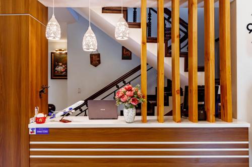 an office with a desk with a laptop and flowers at Nana Homestay & Villa in Hue