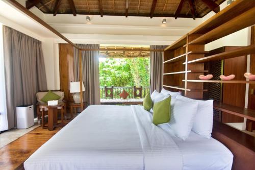 een slaapkamer met een groot wit bed met groene kussens bij Harlan Beach Villa Boracay in Boracay