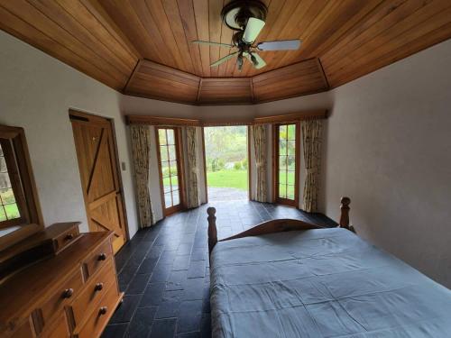 a bedroom with a bed and a ceiling fan at The Bridge House with private pool and jetty in Mangonui