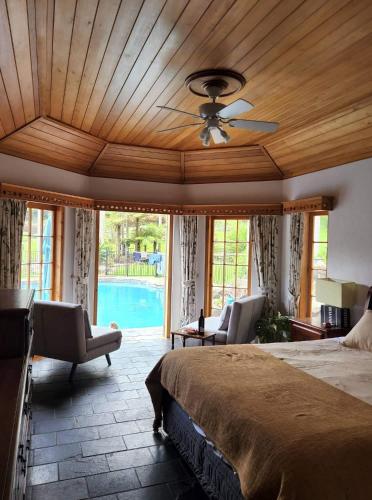 a bedroom with a bed and a ceiling fan at The Bridge House with private pool and jetty in Mangonui