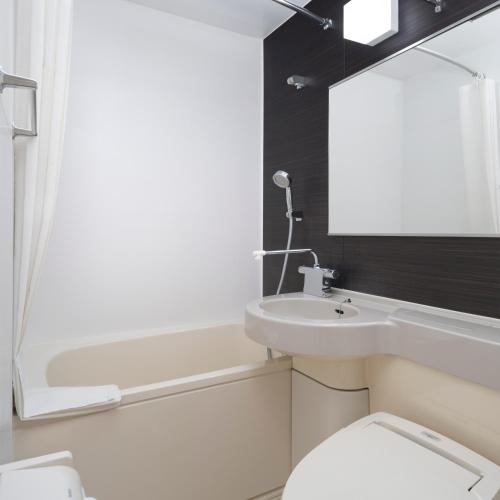 a bathroom with a toilet and a sink and a bath tub at ART HOTEL Nippori Lungwood in Tokyo
