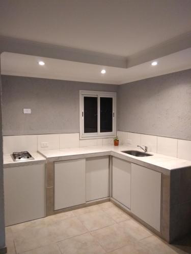 a kitchen with white cabinets and a sink at Villa sol in Cordoba