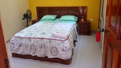 um quarto com uma cama com uma cabeceira de madeira em Hospedaje Paraíso em Tingo María