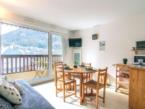 - un salon avec une table, des chaises et une grande fenêtre dans l'établissement Appartement pour 6 à Saint-Lary avec balcon et parking - FR-1-296-446, à Saint-Lary-Soulan