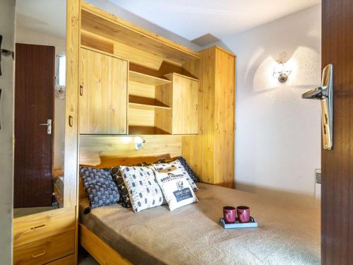 une chambre avec un lit avec une armoire en bois dans l'établissement Appartement pour 6 à Saint-Lary avec balcon et parking - FR-1-296-446, à Saint-Lary-Soulan