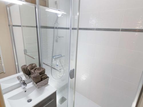 une salle de bain blanche avec une douche et un lavabo dans l'établissement Appartement pour 6 à Saint-Lary avec balcon et parking - FR-1-296-446, à Saint-Lary-Soulan