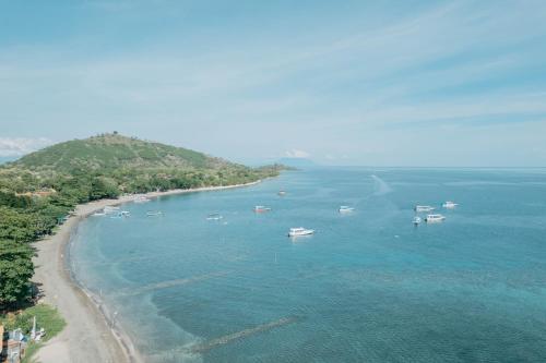 an aerial view of a beach with boats in the water at Global Royal Pemuteran in Pemuteran
