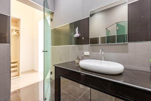 a bathroom with a white sink on a black counter at 3 Bedroom Pool Villa BL2 in Hua Hin