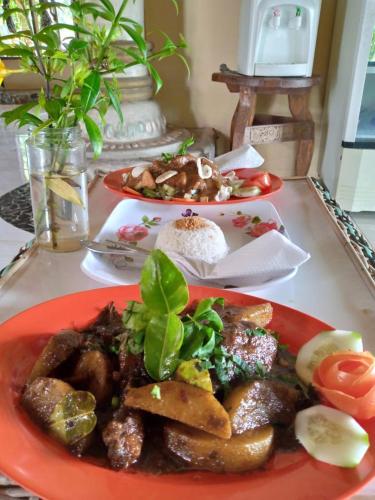 a table with two plates of food on it at Sumatra Cheeky Monkeys in Bukit Lawang