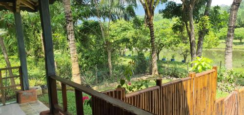 a porch with a wooden fence and trees at Sumatra Cheeky Monkeys in Bukit Lawang