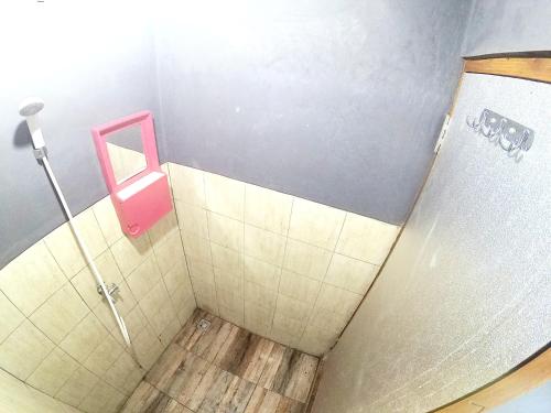 une salle de bains avec un urinoir rose sur le mur dans l'établissement Degolan Wooden House, à Ngemplak
