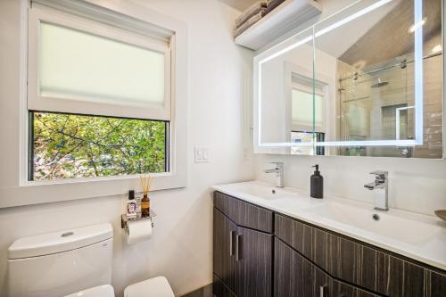 ein Bad mit einem WC, einem Waschbecken und einem Fenster in der Unterkunft Luxury River Home - Pets Stay Free in Monte Rio