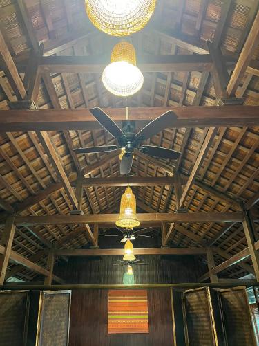 a ceiling fan and lights on a wooden ceiling at Mường Sang Retreat in Mộc Châu