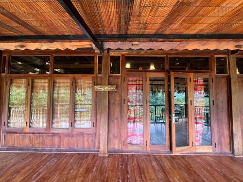 an empty room with wooden doors and stained glass windows at Mường Sang Retreat in Mộc Châu