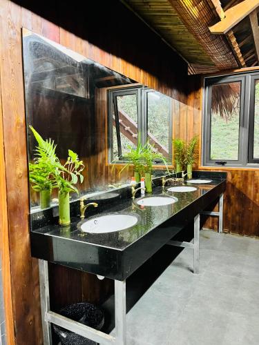 a bathroom with three sinks with plants on the counter at Mường Sang Retreat in Mộc Châu