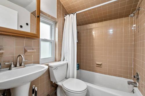 a bathroom with a toilet and a sink and a tub at Spacious Home, 15min from Downtown, Private Garage & Patio in Pittsburgh