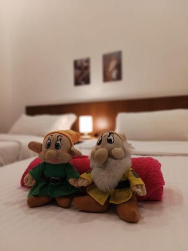 two stuffed animals are sitting on a bed at Nova Sunrise n Mountain view Hilltop Hotel apartment in Nova Cameron Highlands in Brinchang