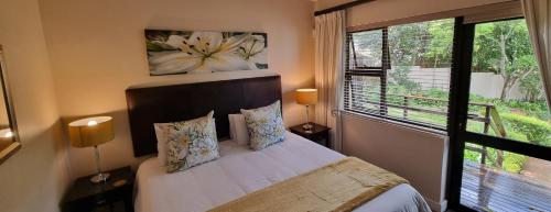 ein Schlafzimmer mit einem Bett und einem großen Fenster in der Unterkunft SomerZicht Guest House in Somerset West