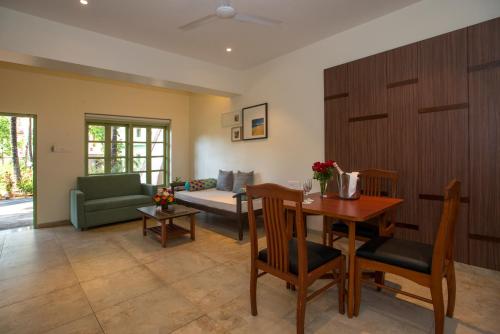 a living room with a table and a couch at Nanu Beach Resort & Spa in Betalbatim