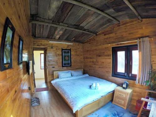 a bedroom with a large bed in a wooden room at Amica House in Sa Pa