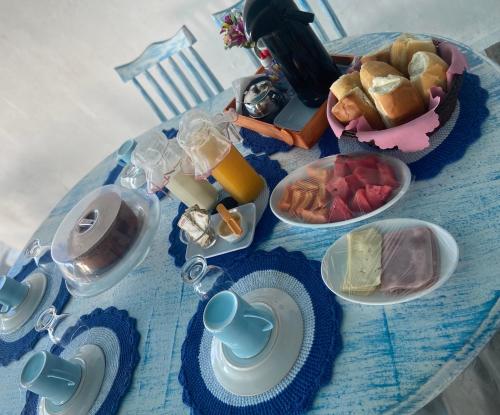 une table avec un chiffon bleu et de la nourriture dans l'établissement Pousada La Grécia, à Camocim