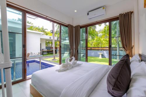 ein Schlafzimmer mit großem Bett und Pool in der Unterkunft 4 Bedroom Modern Pool Villa BL10 in Hua Hin