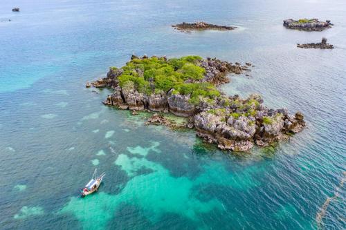 an island in the ocean with a boat in the water at Chole Mjini Treehouses Lodge in Utende