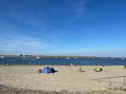 a group of people on a beach near the water at Bed & Wellness Chinel Luxe vakantiehuis met Sauna's en Bubbelbad in Sint Annaland