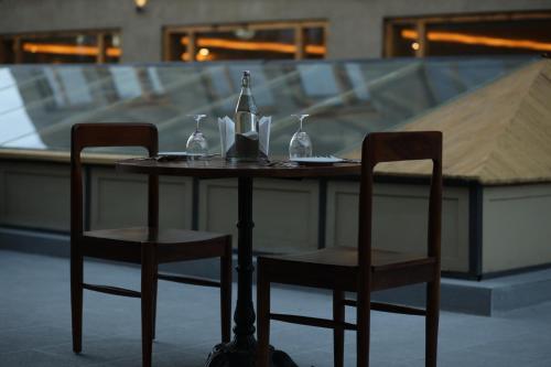 a table with two chairs and a bottle and wine glasses at Pal Hotel in Leh