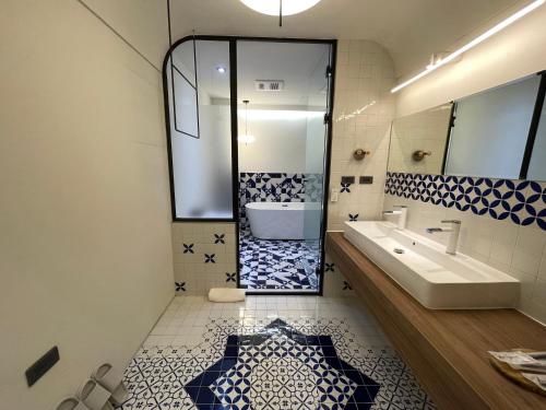 a bathroom with a tub and a sink and a mirror at Green Inn Kaohsiung in Kaohsiung