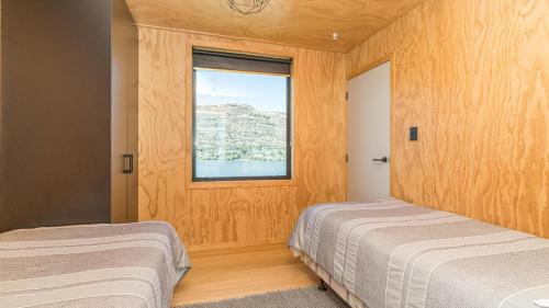 una camera con due letti e una finestra di Picture Perfect - Queenstown Holiday Home a Queenstown