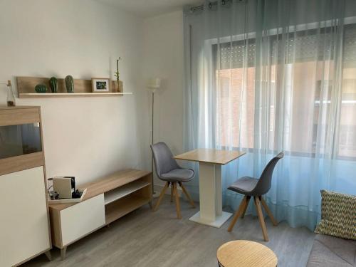 uma sala de estar com uma mesa e cadeiras e uma janela em Oasis Plus em Sevilha