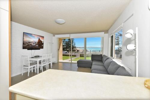 una sala de estar con un sofá y una mesa en Waterviews on Marine Apartment 1, en The Entrance