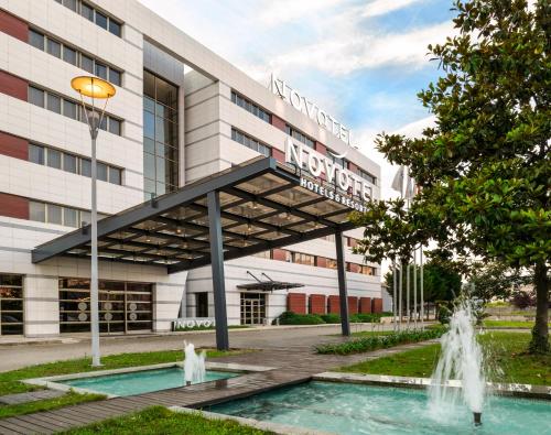 a building with a fountain in front of a building at Novotel Trabzon in Trabzon