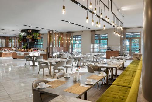 a restaurant with tables and chairs and a cafeteria at Novotel Trabzon in Trabzon