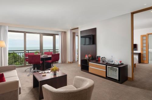 a living room with a couch and a table with chairs at Novotel Trabzon in Trabzon