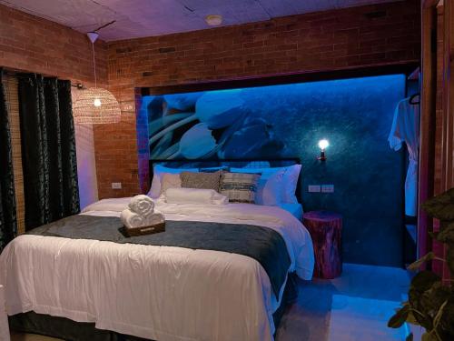 a bedroom with a large bed with a blue wall at Blue Tulip in Pusok
