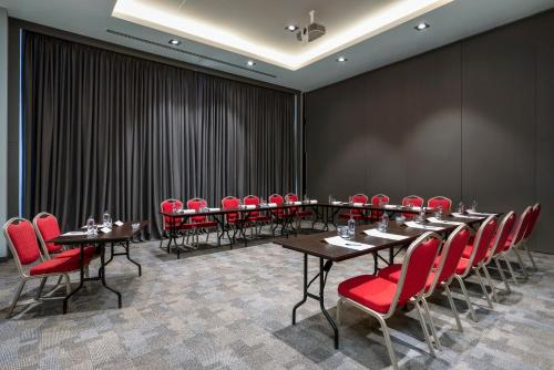 a conference room with tables and red chairs at Novotel Trabzon in Trabzon
