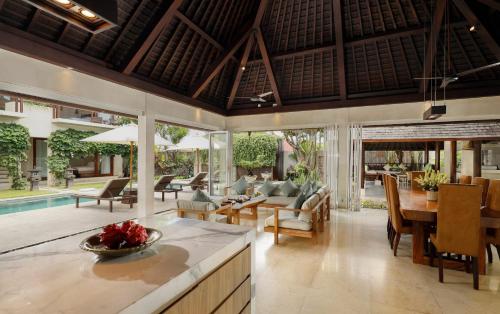 a kitchen and living room with a table and chairs at Villa Tenang by Nakula in Canggu