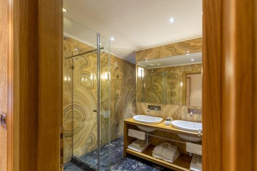 a bathroom with two sinks and a shower at Hotel Vardar in Kotor