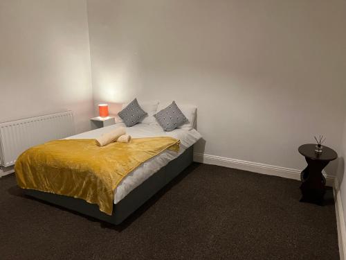 a bedroom with a bed with a yellow blanket at Superb Lime Guest House in Shildon