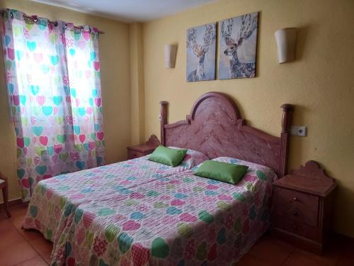 a bedroom with a pink bed with two green pillows at Casa Beatriz in Cala San Vicente