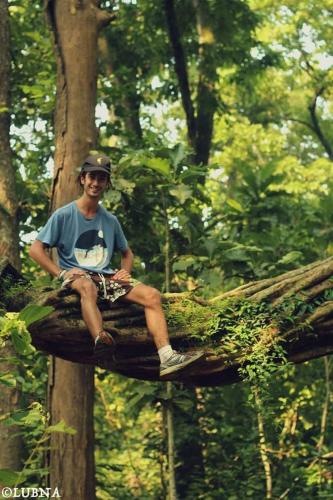a man sitting on top of a tree branch at Crocodile Safari Camp in Chitwan