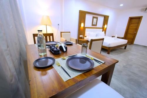 a wooden table with plates on it in a room at HOTEL WHITE HOUSE, Munnar in Munnar