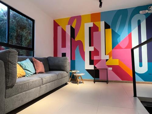 a living room with a couch and a colorful wall at HOTEL 9.5 SAN FERNANDO in Cali
